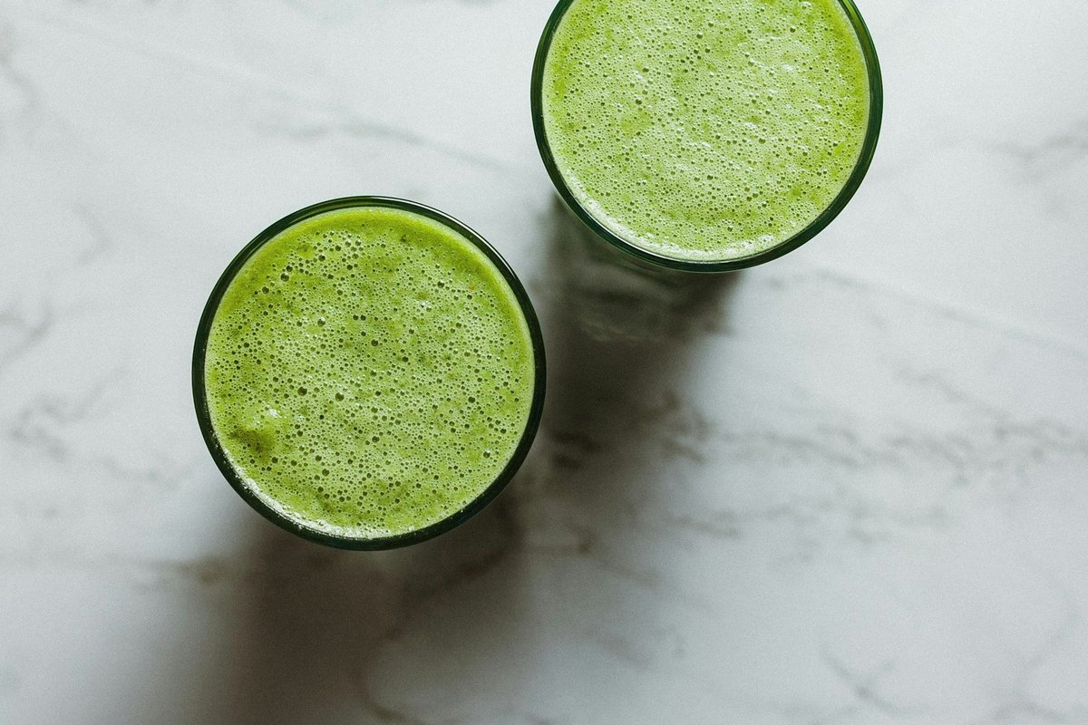 Deux verres de jus vert vus de dessus sur un plan de marbre