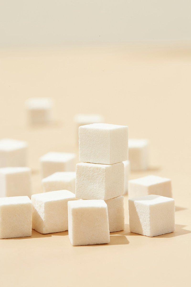 Morceaux de sucre empilés sur un fond beige